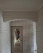 Укладка гипсового декоративного кирпича с аркой.