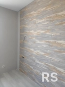 Поверхность была очищена и загрунтована.
Обои нарезаны по размеру, нанесен клей.
Полотна аккуратно приклеены, разглажены для устранения пузырьков.